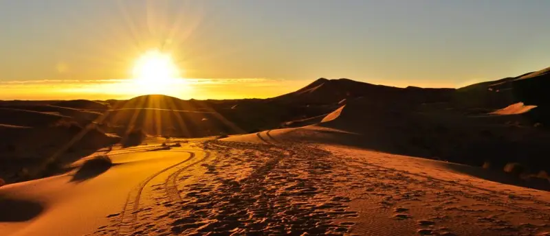 4x4 tyre tracks across the Erg Chebbi dunes at sunset