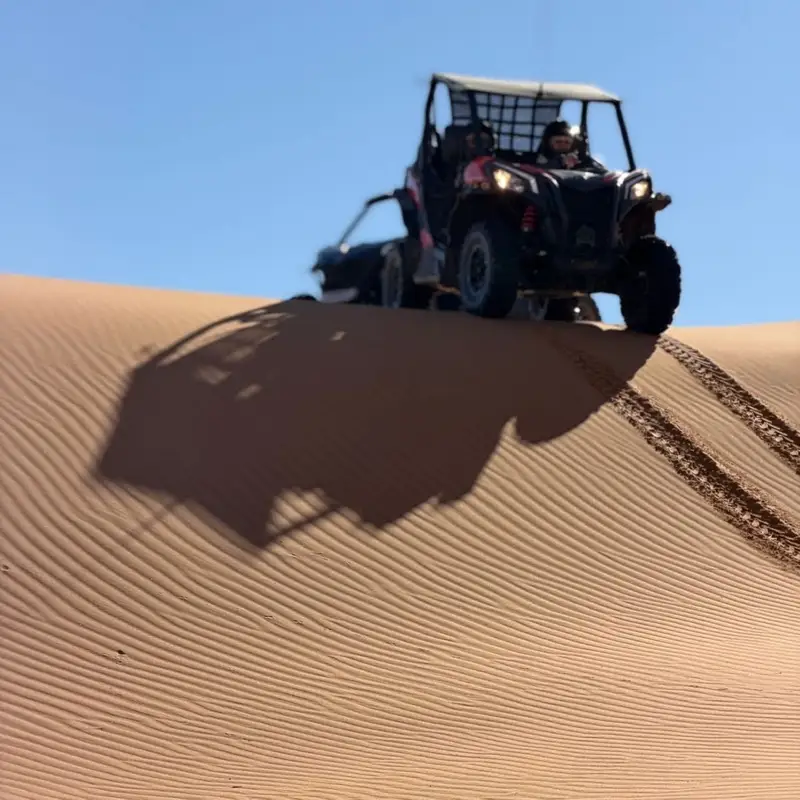 Buggy climbing to the top of a dune