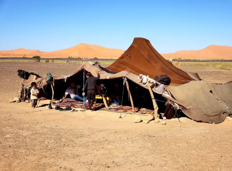 Nomad family tent on the plain with the Erg Chebbi dunes behind