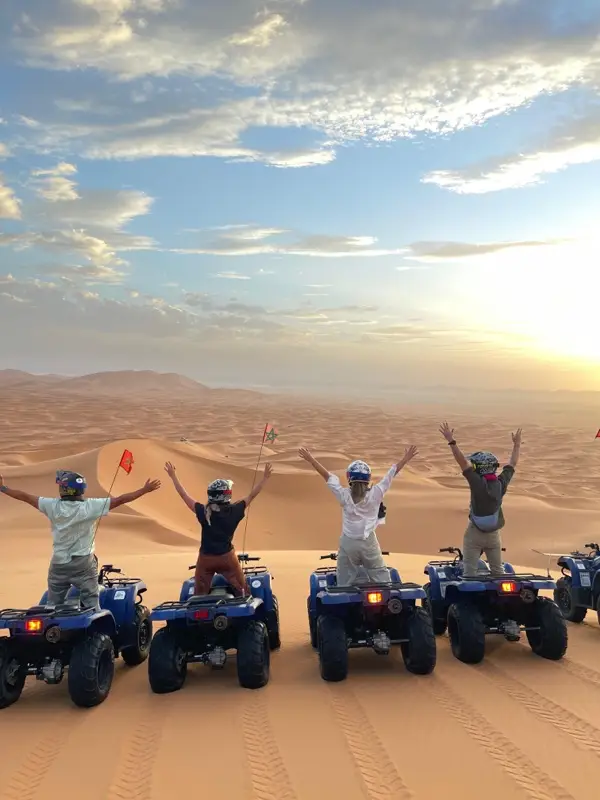 Riders cheering on their quads at sunset