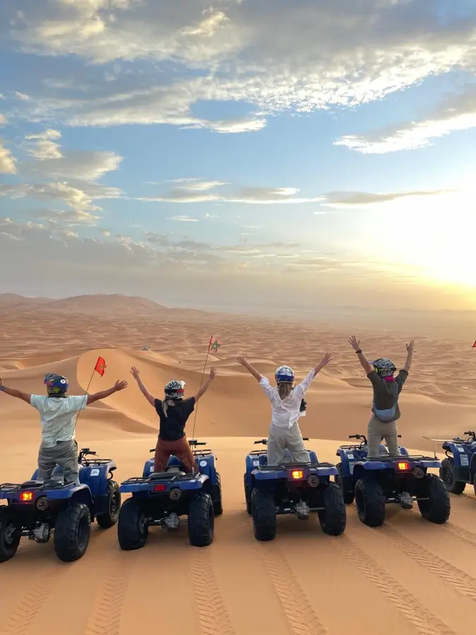 Riders cheering on their quads at sunset